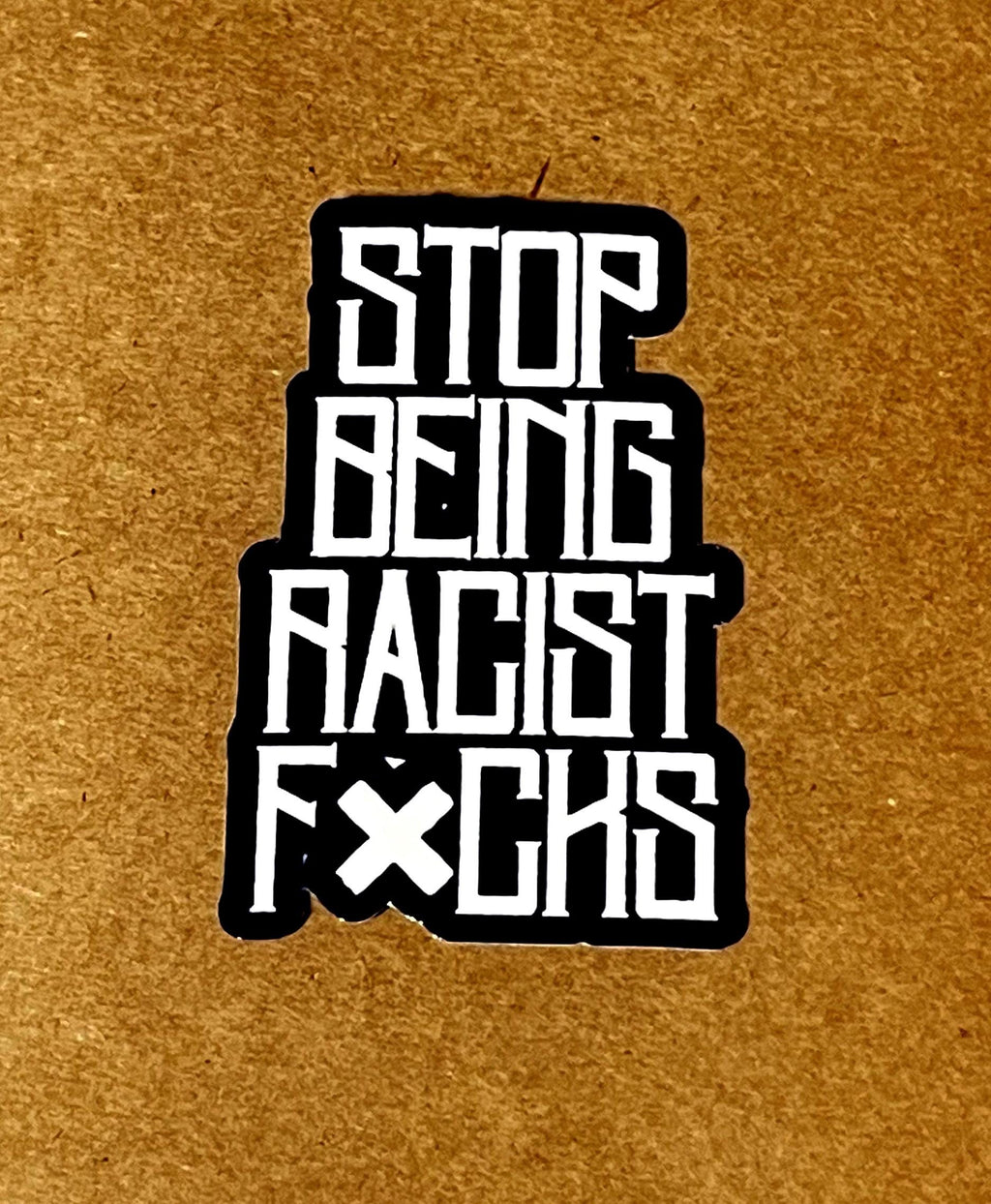 the text "STOP BEING RACIST FUCK'S" in a bold, white font against a black background.