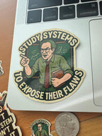 a sticker with a cartoon illustration of a man wearing glasses and holding a book, along with the text "Study Systems to Expose Their Flaws".