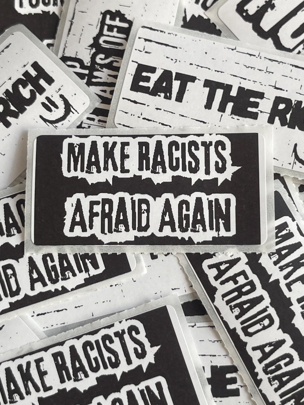 a collection of stickers with the text "Make Racists Afraid Again" printed on them.