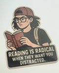 A sticker depicting a person reading a book, with the text "Reading is Radical When They Want You Distracted."