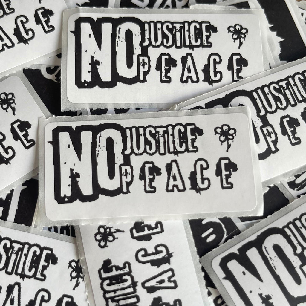 multiple stickers with the text "NO JUSTICE / PEACE" printed on them.