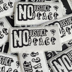 multiple stickers with the text "NO JUSTICE / PEACE" printed on them.
